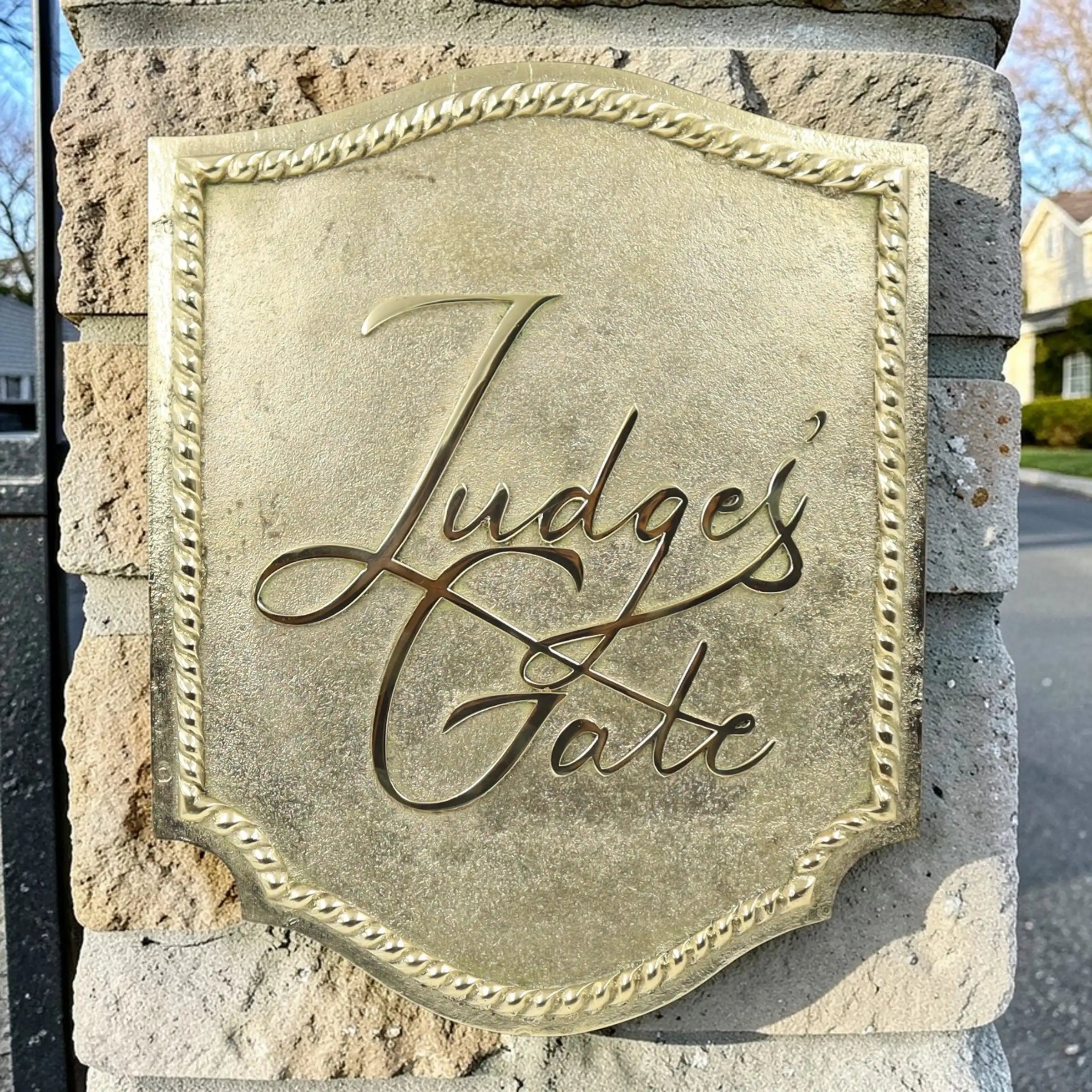  Brass plaque with 'Judge's Gate' engraved on a stone wall.