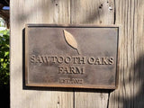 Brass plaque with 'Sawtooth Oaks Farm' on a wooden background