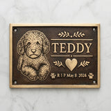 Bronze Memorial plaque for a dog named Teddy with engraved text and illustrations on a marble background