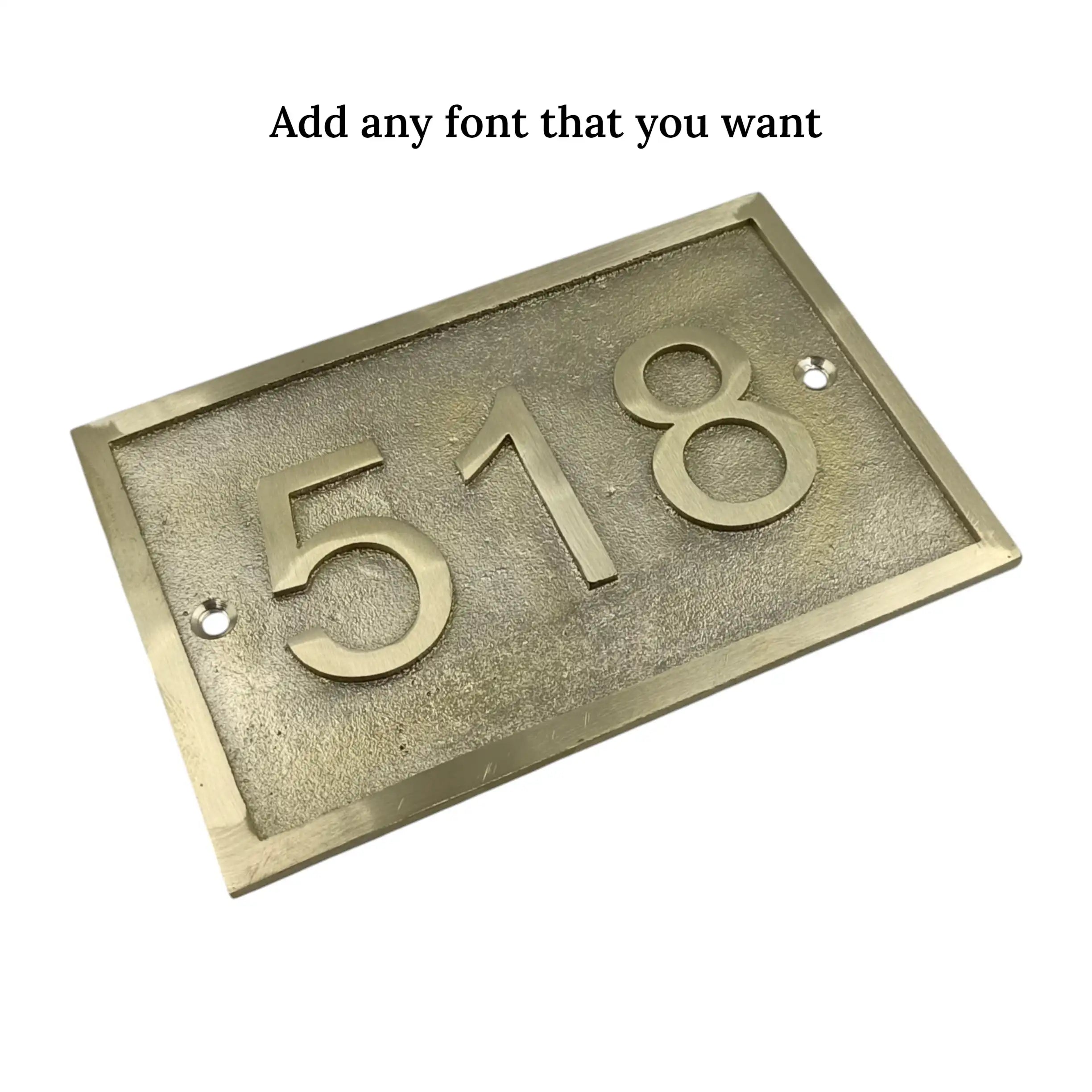 Brass house number plate with '518' on a white background