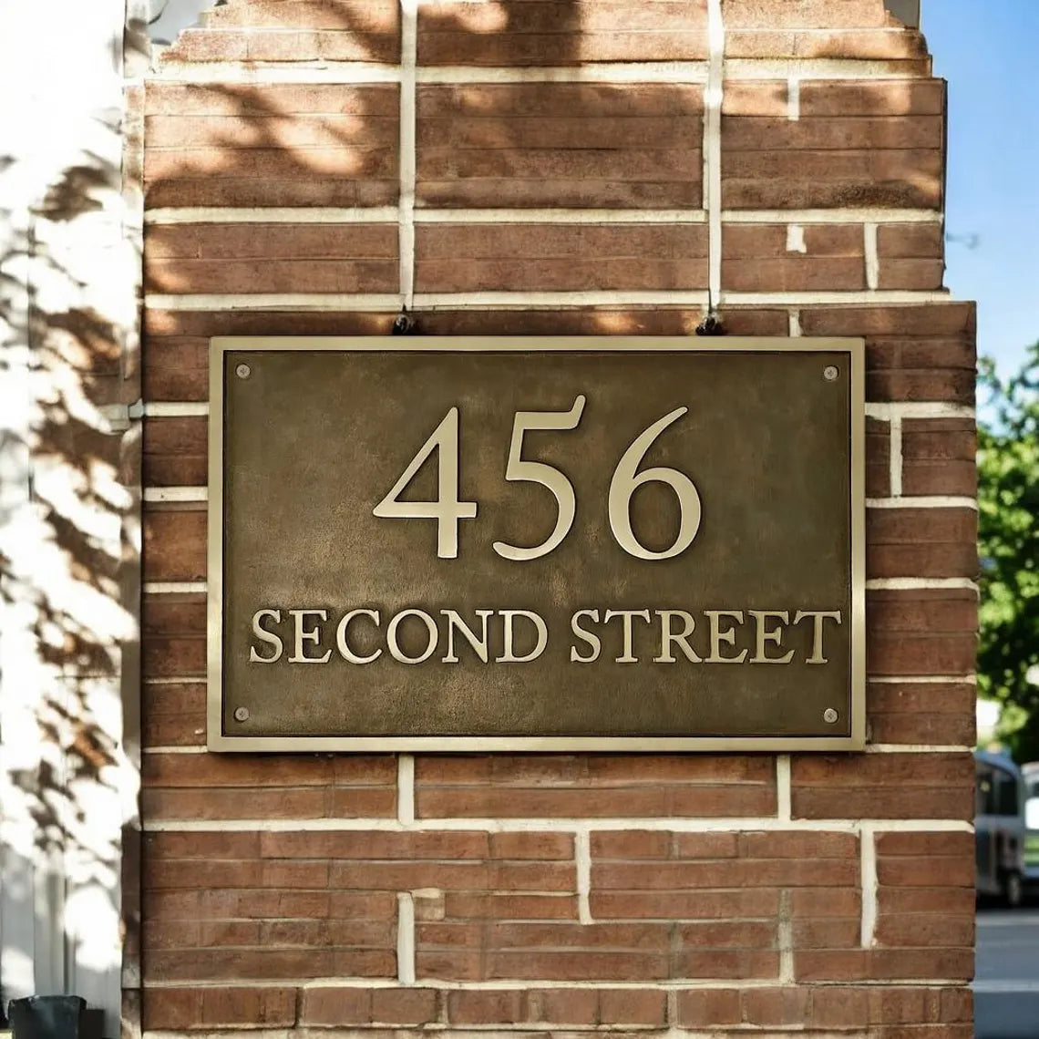 Address sign on a brick wall with '456 Second Street' text