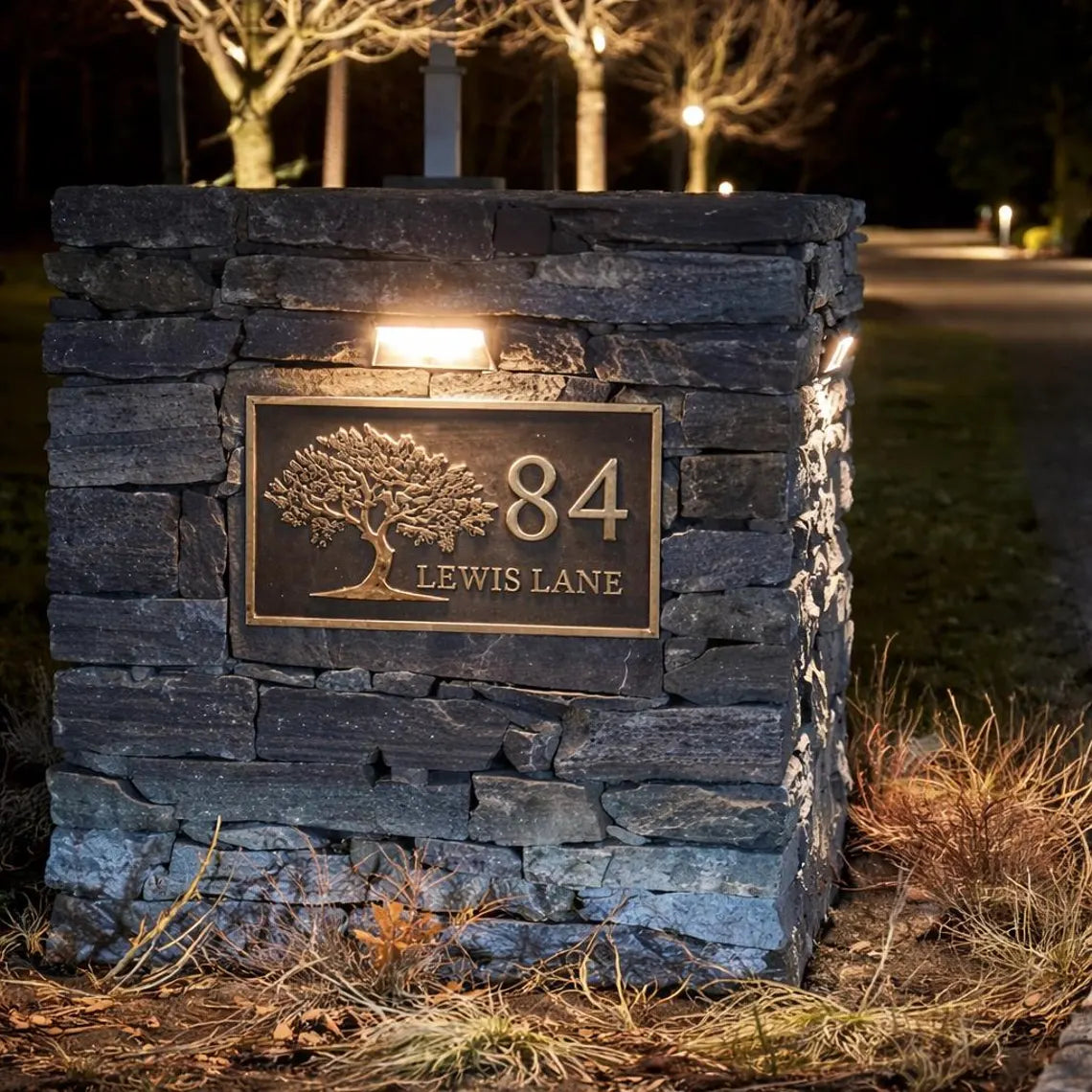 Stone wall with house number and name plaque at night