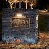Stone wall with house number and name plaque at night