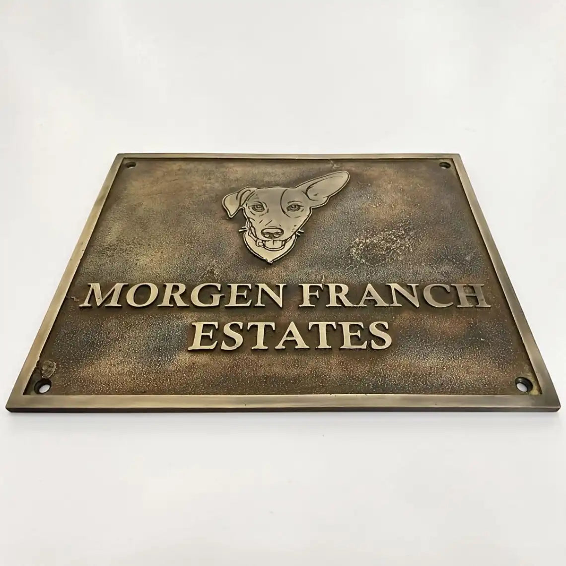 Bronze plaque with a dog illustration and 'Morgen Franch Estates' text on a white background