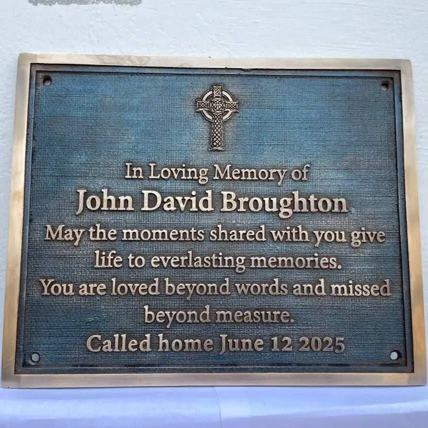 Memorial plaque for John David Broughton with a Celtic cross design on a blue background.