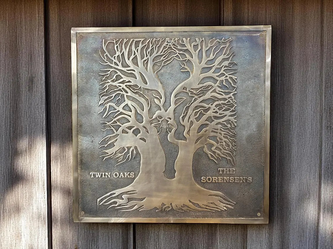 Bronze plaque with tree design and engraved text on a wooden background
