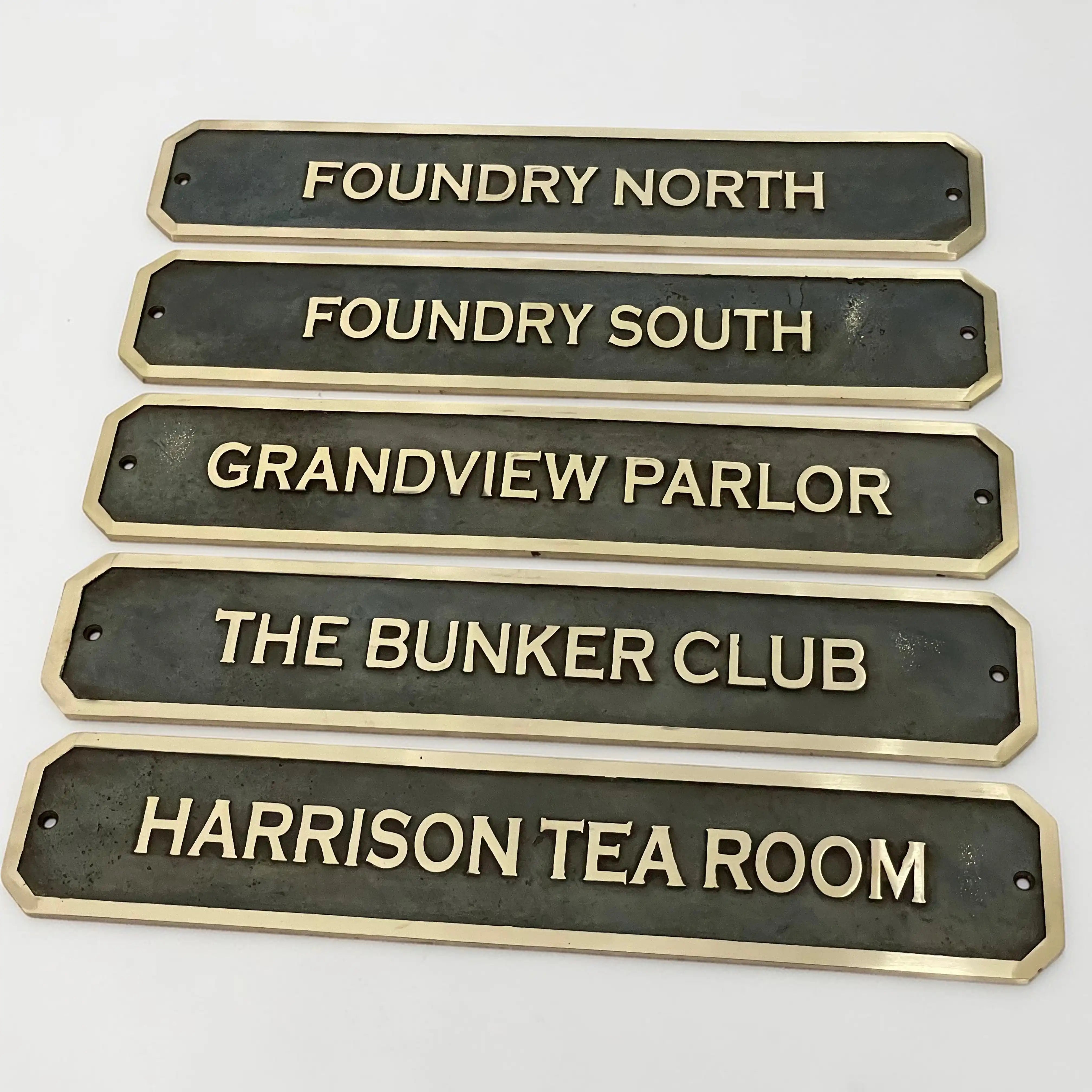 Bronze signs with engraved names on a white background