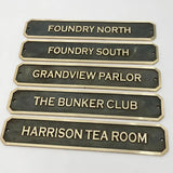 Bronze signs with engraved names on a white background