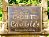 Bronze plaque on stone wall with 'Hotel Everett Carlisle's' text