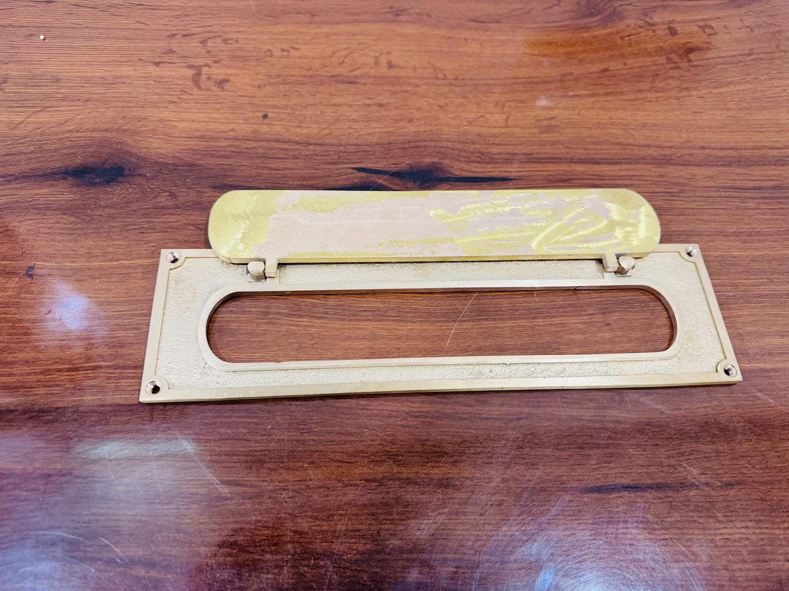 Brass letter opener with yellow handle on a wooden surface