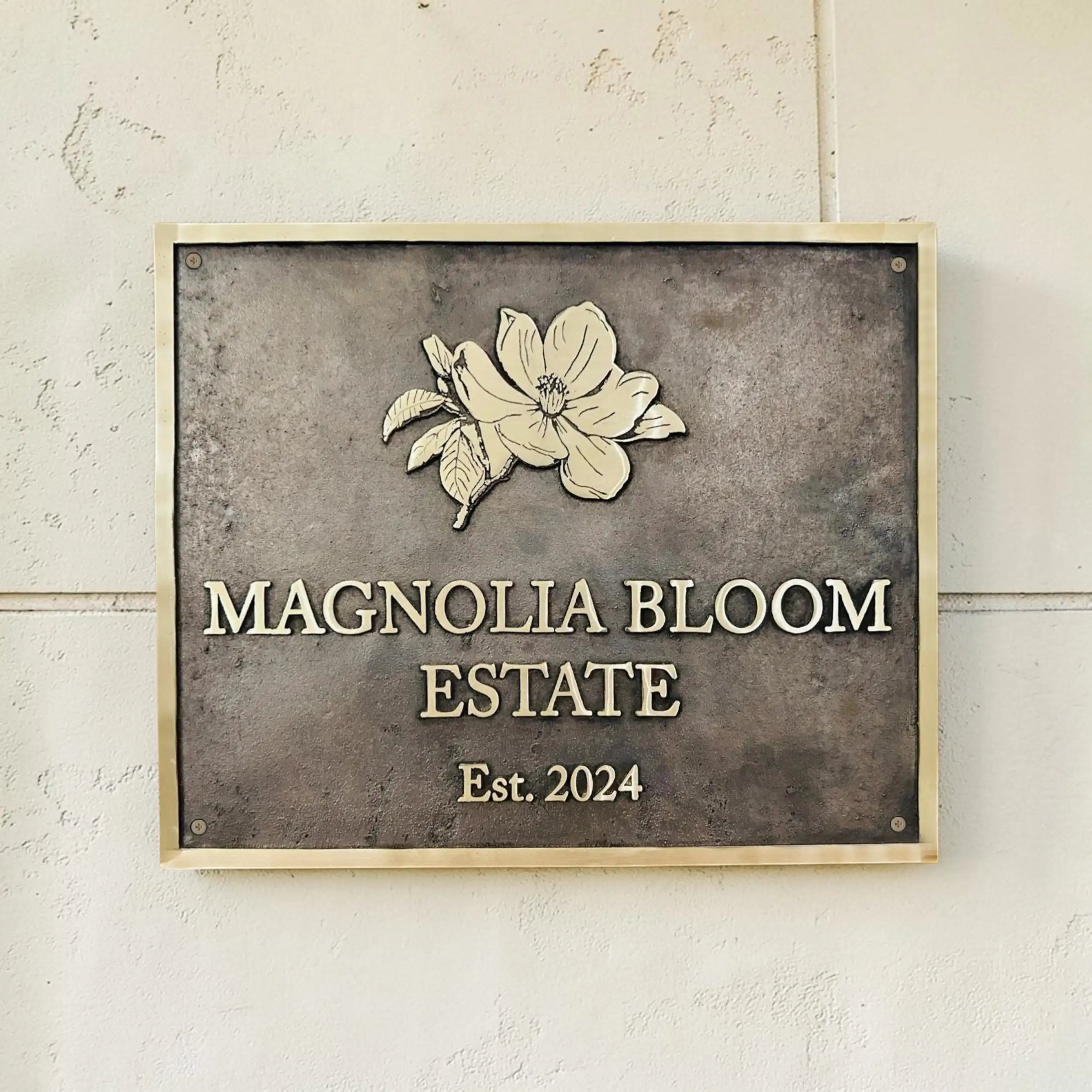 Bronze plaques Address sign with floral design and text on a textured wall