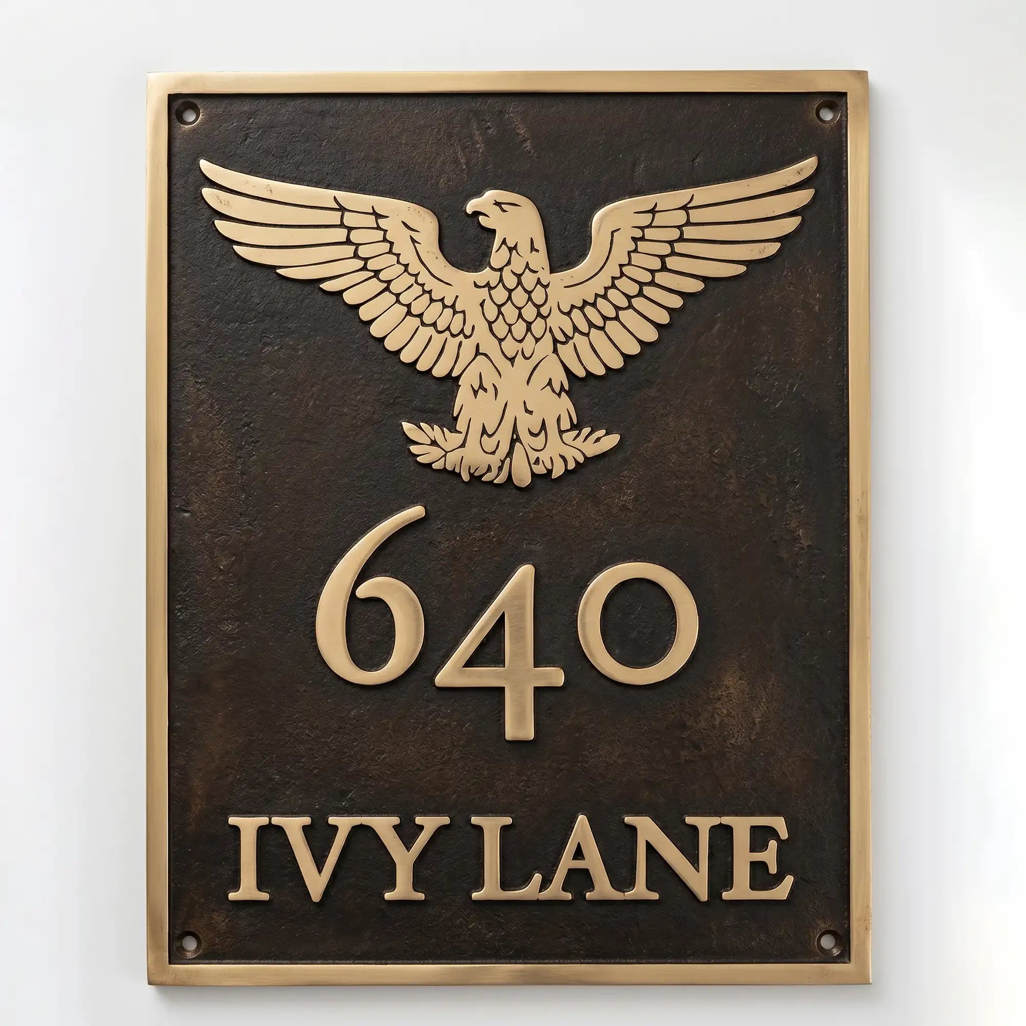 Bronze or brass address plaque featuring a cast eagle emblem above the house number and street name.