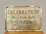 Brass plaque with engraved text on a wooden surface