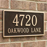 House number sign with '4720 Oakwood Lane' on a brick wall