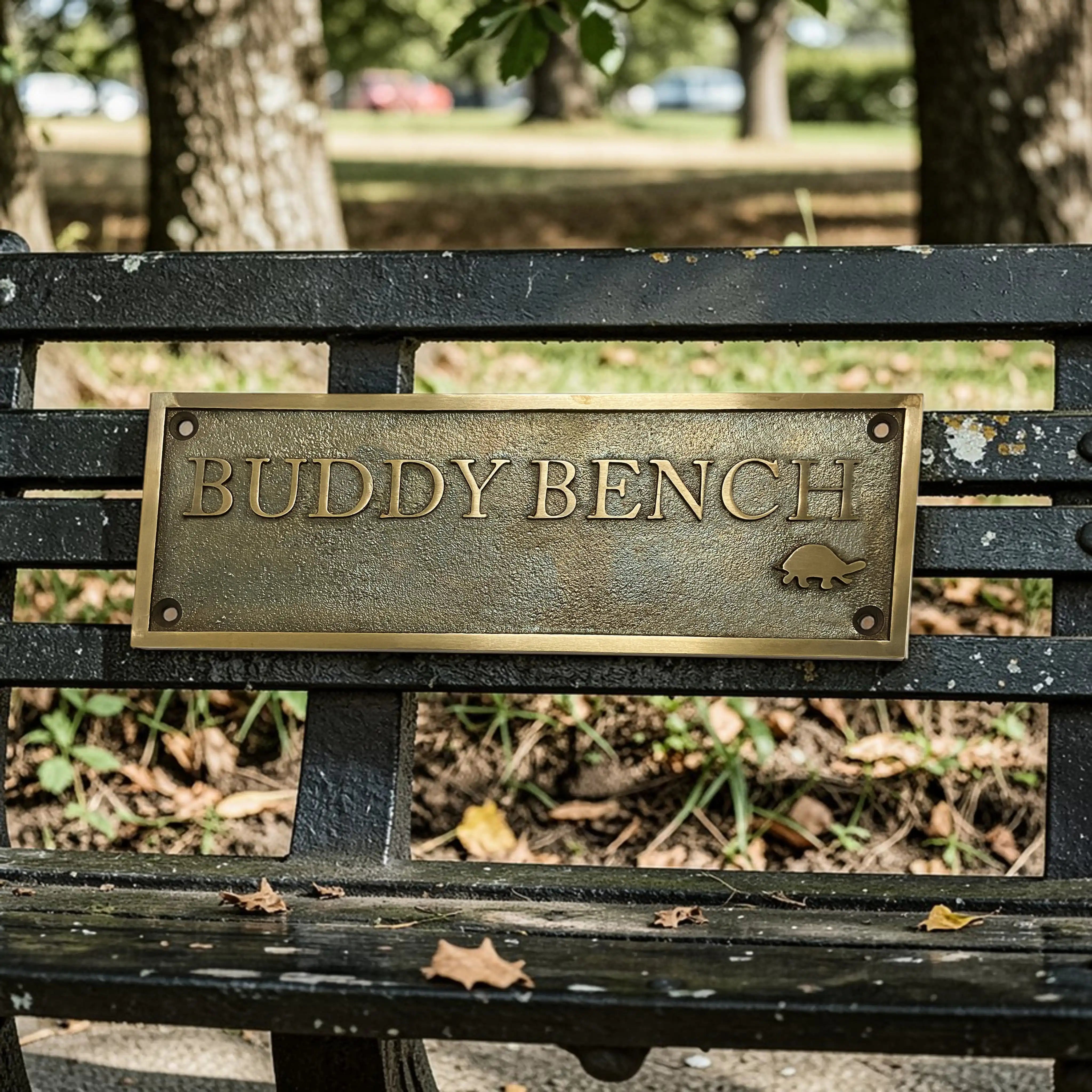 Buddy Bench with a brass plaque in a park setting