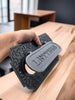 Decorative black metal door handle with 'Leylvers' branding on a wooden surface.