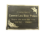 Memorial plaque with engraved text and floral designs on a white background