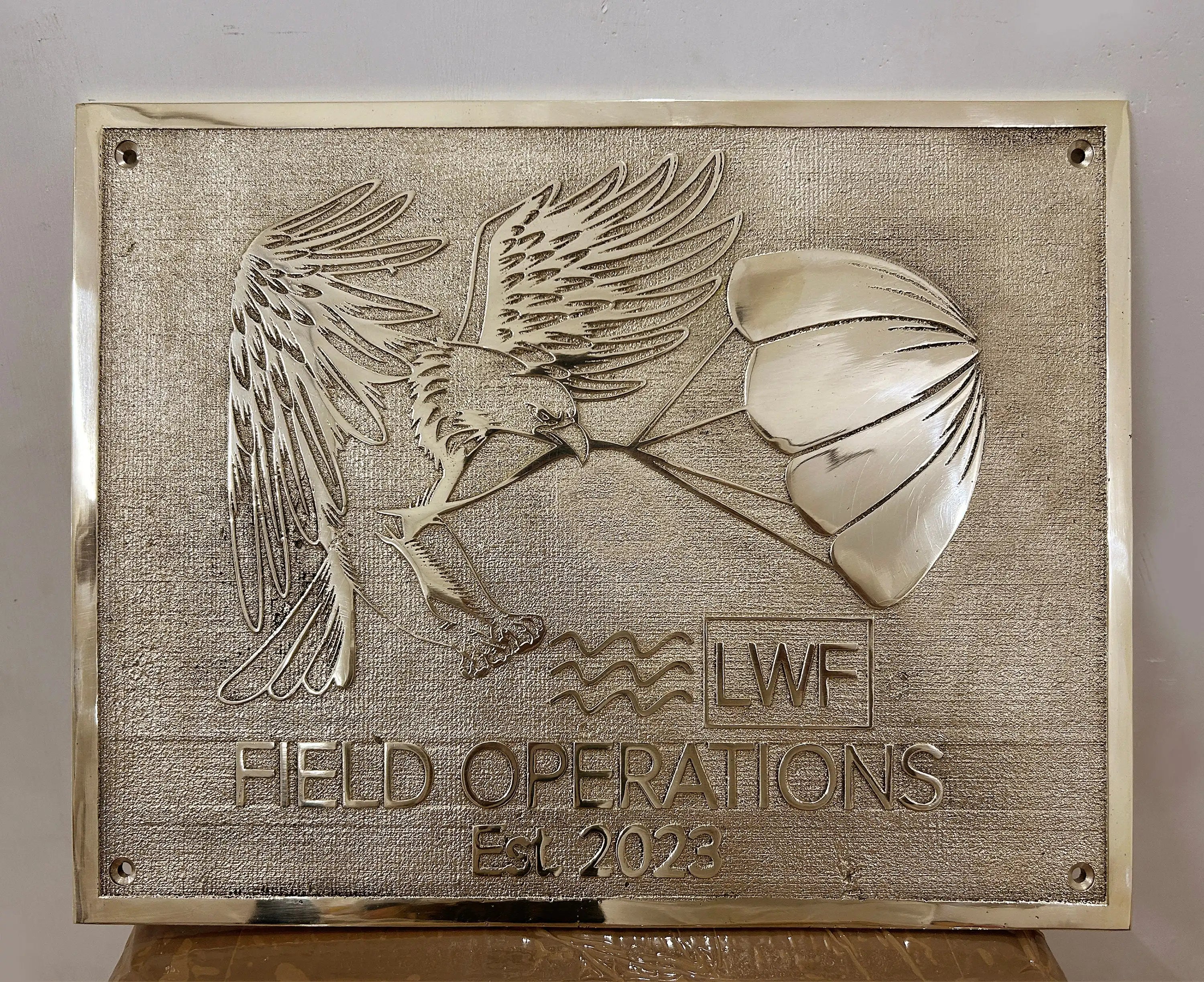 Bronze plaque with an eagle and parachute design, featuring 'LWF Field Operations Est. 2023'.