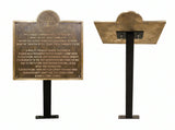 Bronze plaque on a stand with engraved text on a white background