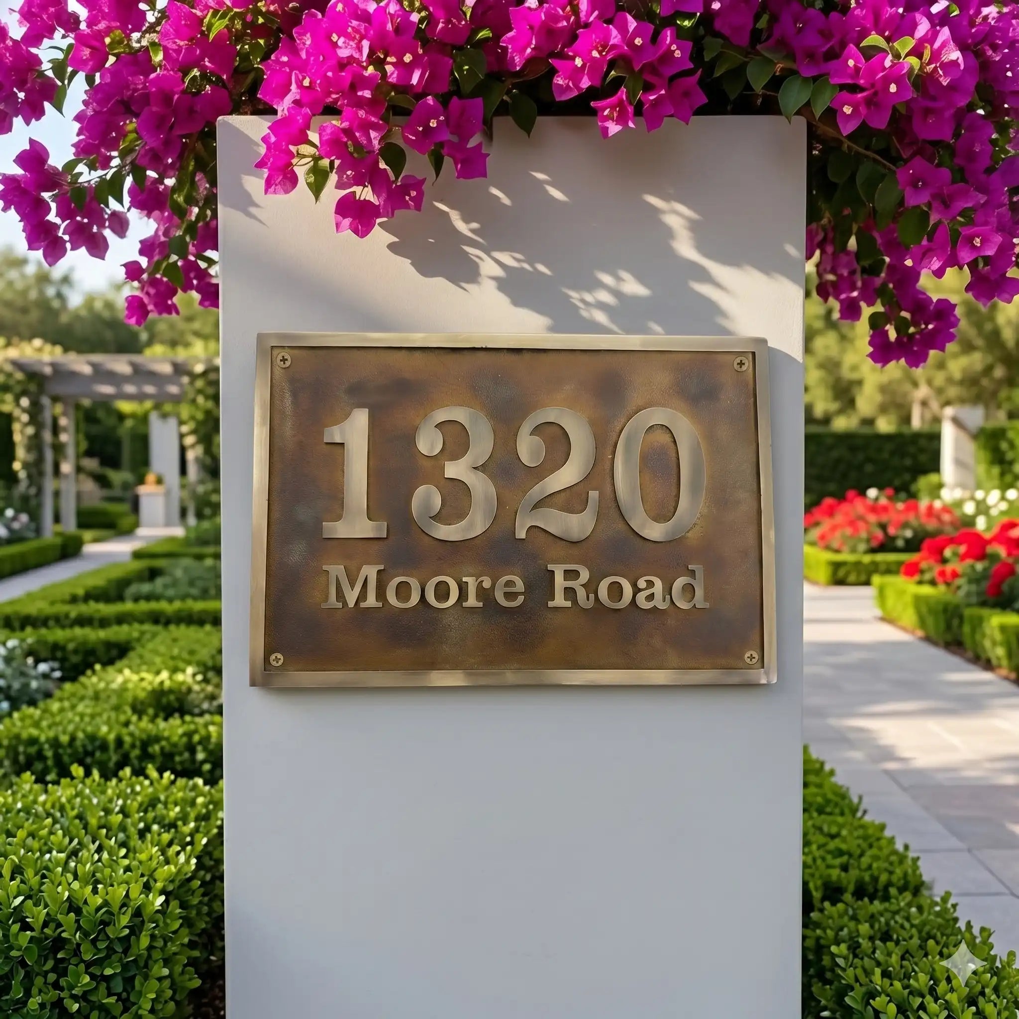 Bronze Address sign on a wall with pink flowers above it