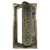 Brass mail slot for door installed on wooden front door exterior