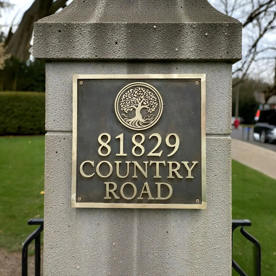 Address plaque on a stone post with '81829 Country Road' text and a tree design.