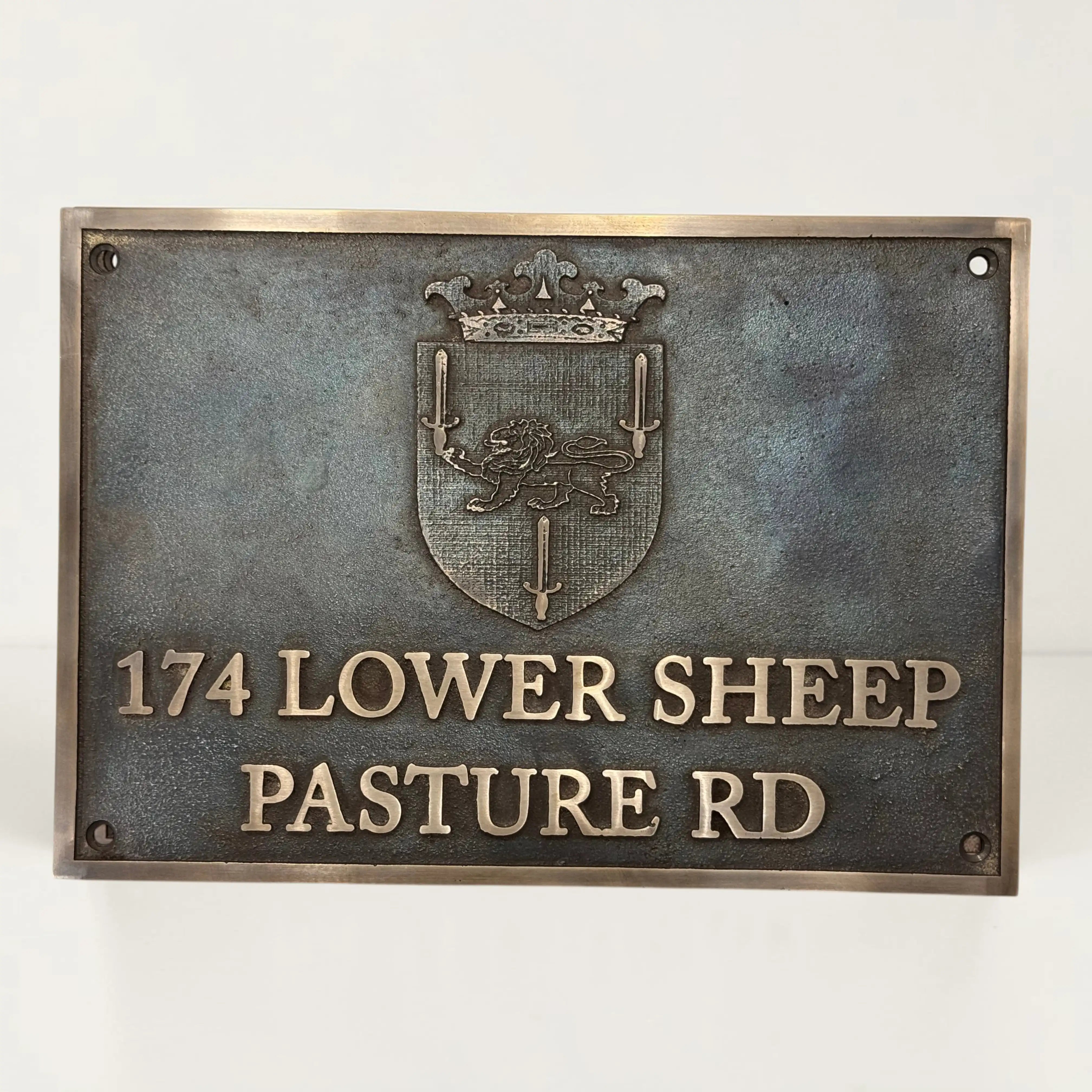 Bronze metal sign with emblem and text on a white background