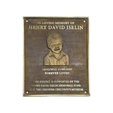 A rectangular bronze memorial plaque with rounded corners, featuring an engraved portrait of a young boy and personalized text reading 'In Loving Memory of Henry David Iselin' and 'Forever Loved,' on a plain white background.