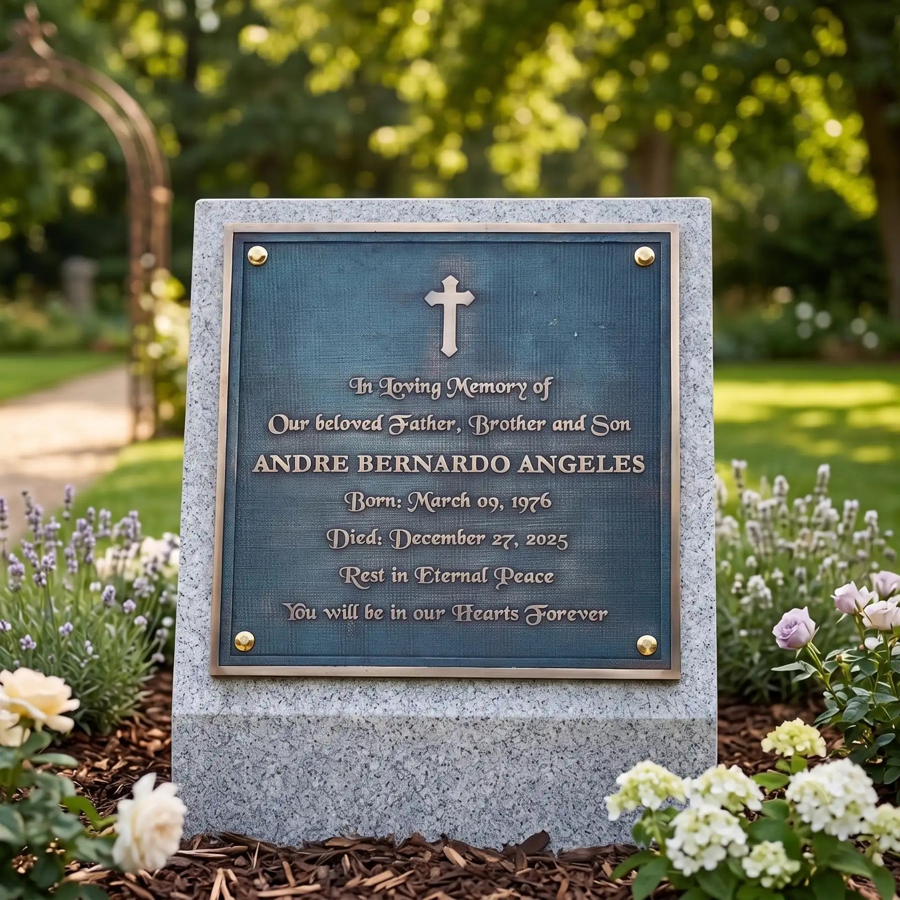 Bronze Memorial plaque for Andre Bernardo Angeles in a garden setting with flowers and greenerye 