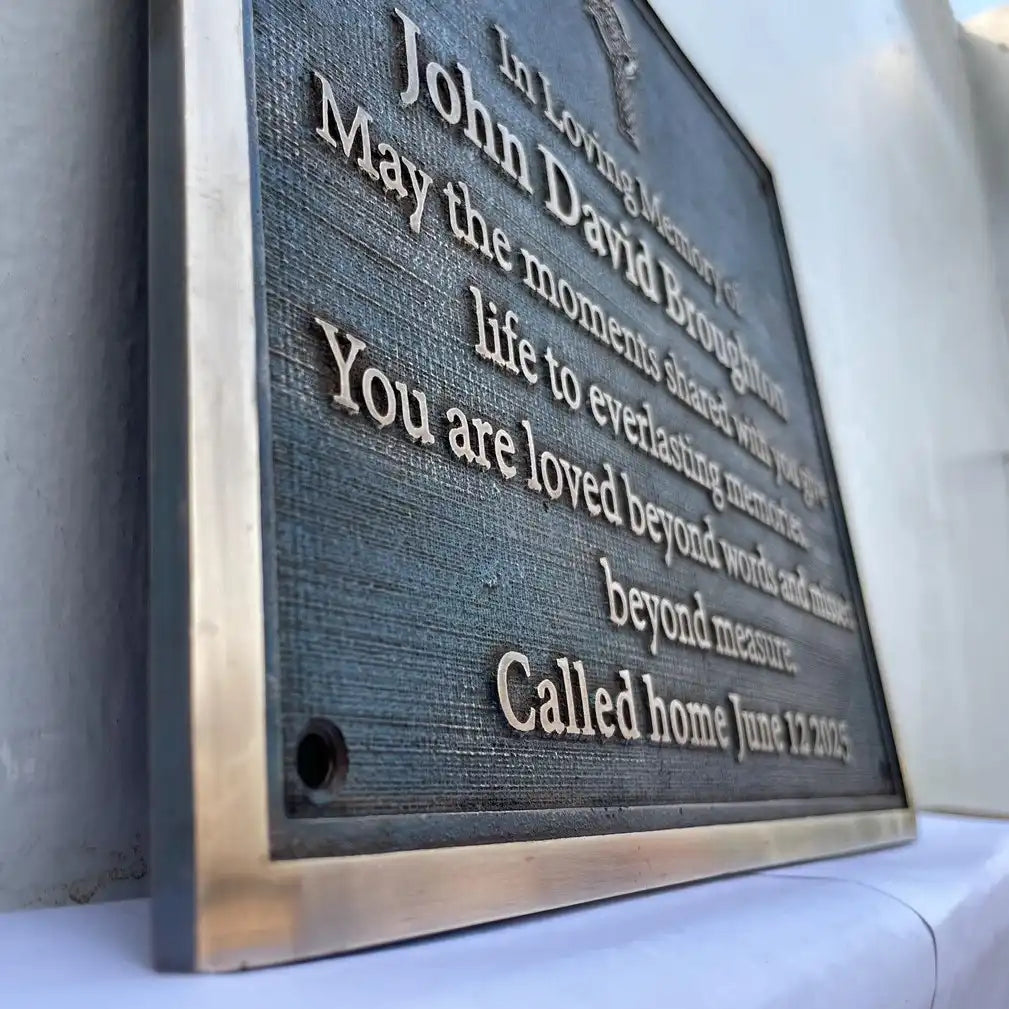 Memorial plaque with engraved text on a white surface