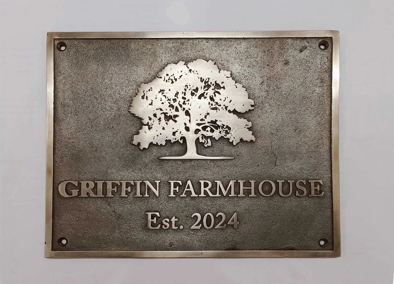 Bronze plaque with an oak tree design and 'Griffin Farmhouse Est. 2024' text on a gray background