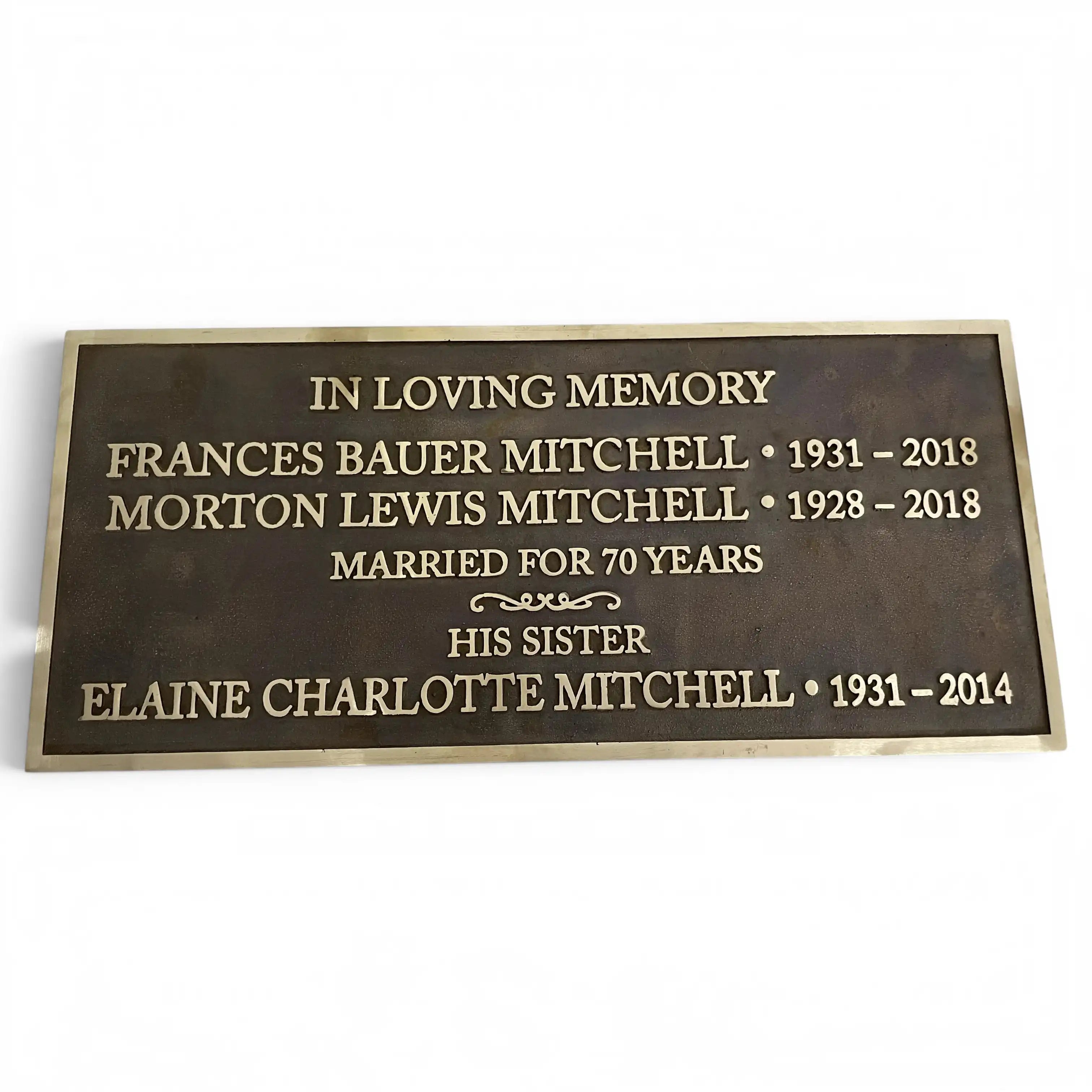 A rectangular bronze memorial plaque with engraved gold lettering, shown against a plain white background.