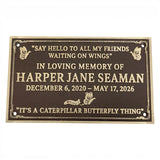 A rectangular dark brown memorial plaque with gold lettering and butterfly illustrations, reading a remembrance message for Harper Jane Seaman with dates and quotes, shown on a plain white background.