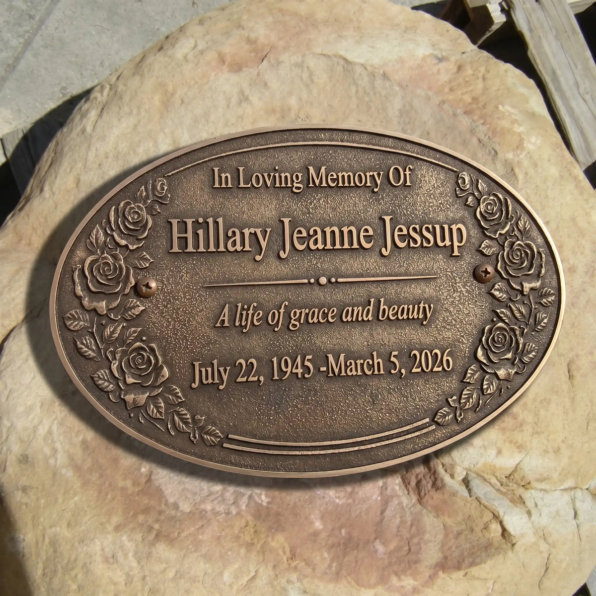 Bronze plaque with engraved text on a stone surface