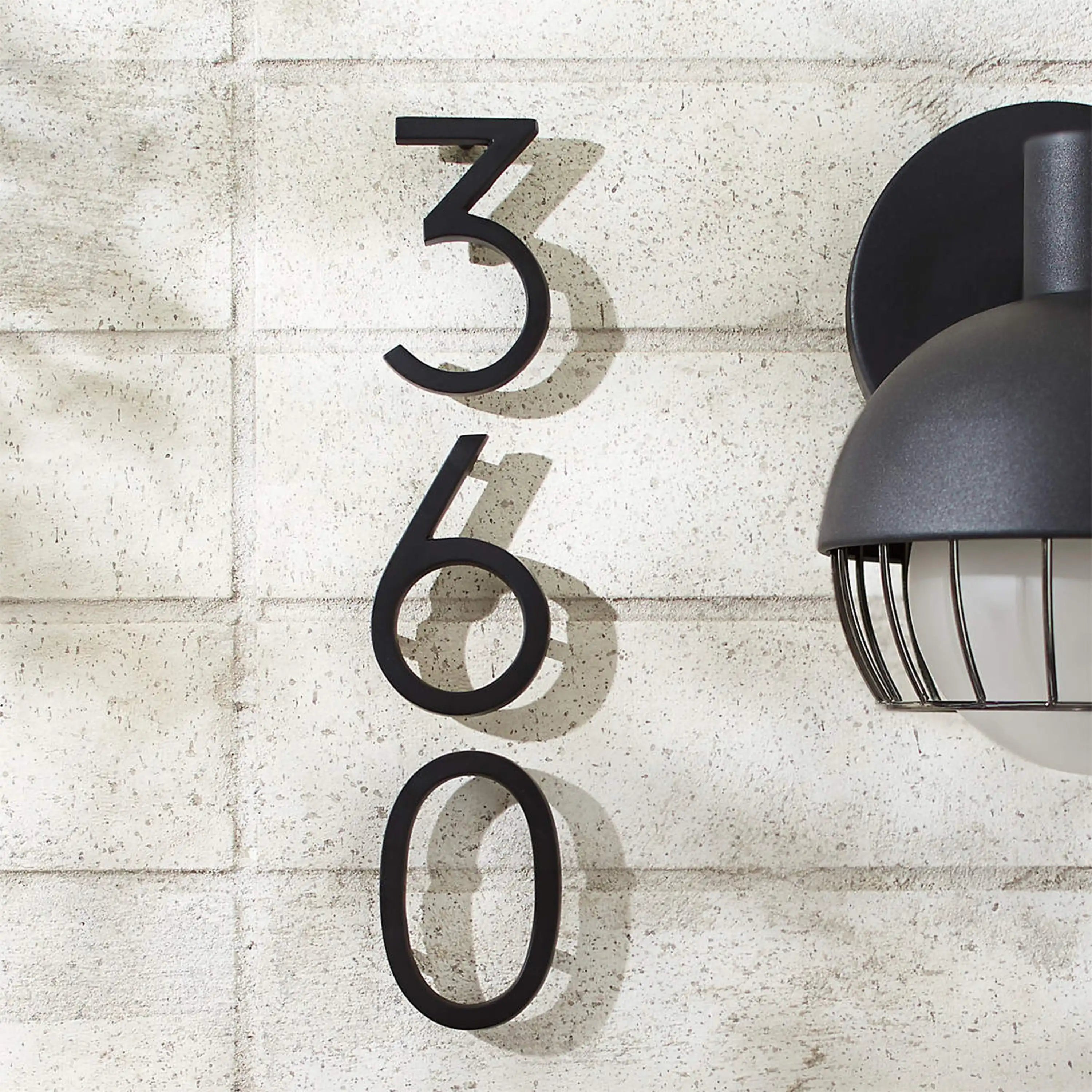 Modern floating black house numbers mounted on exterior wall with hidden studs for a clean contemporary address display