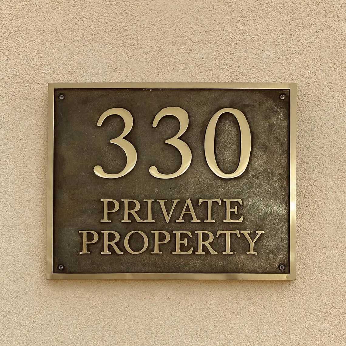 Metallic house number sign with '330' and 'PRIVATE PROPERTY' text on a beige wall.