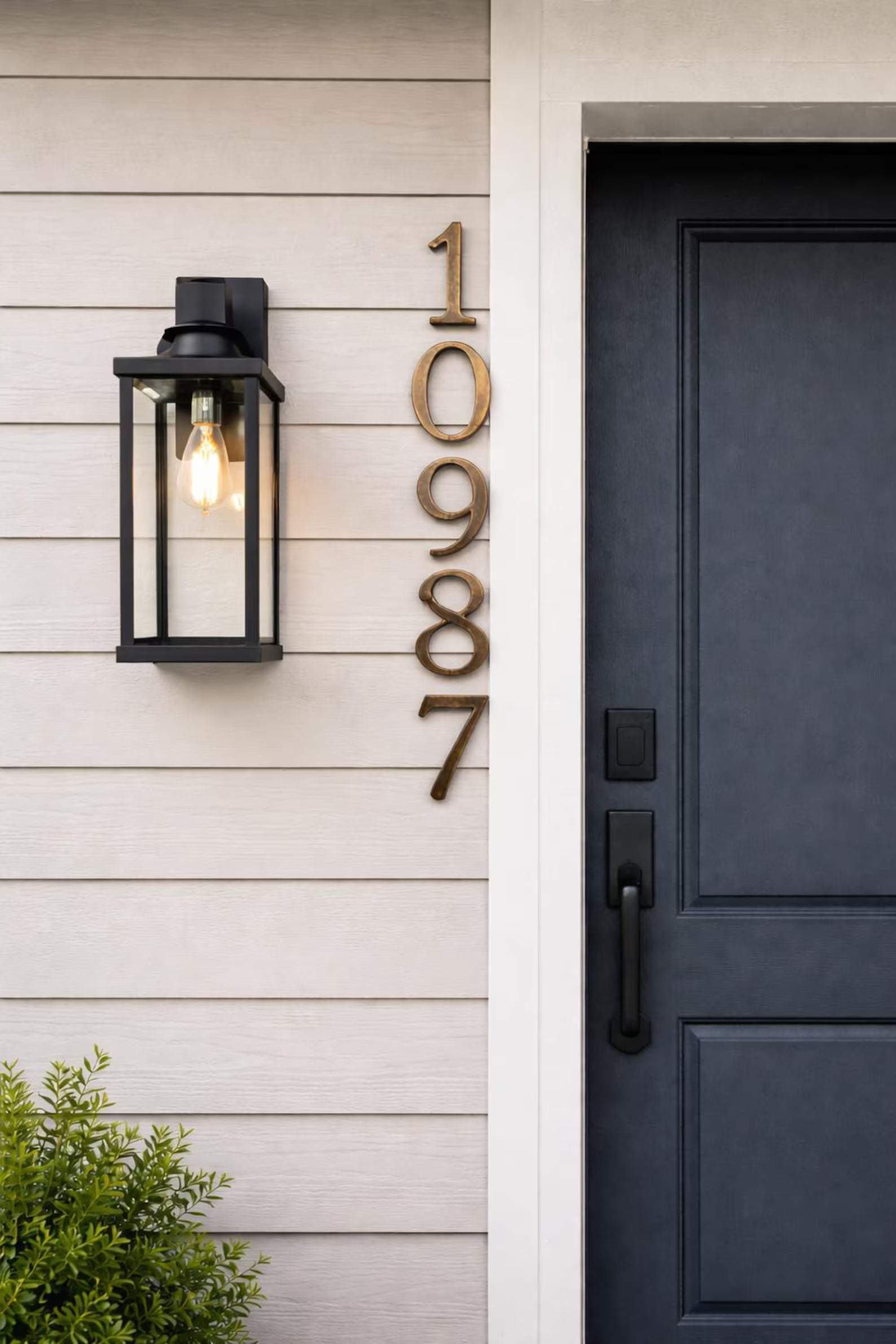 Vertical solid bronze address numbers in an oil rubbed bronze finish mounted on a wall